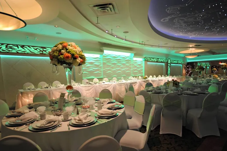 Wedding reception in Full Ballroom with Green lights and chair sashes